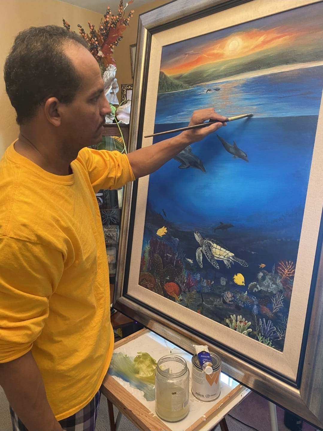 Adañ Torres painting in his studio
